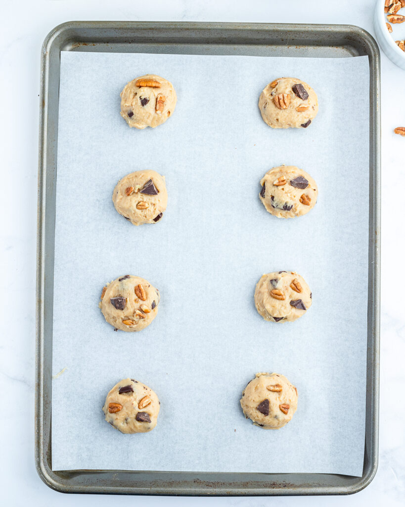 Cookie dough balls on a baking pan.