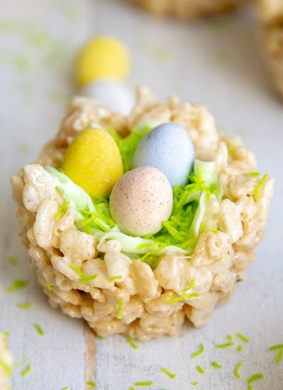 An Easter Rice Krispie treat Nest, decorated to look like a nest with green frosting and chocolate eggs to look like a bird nest.