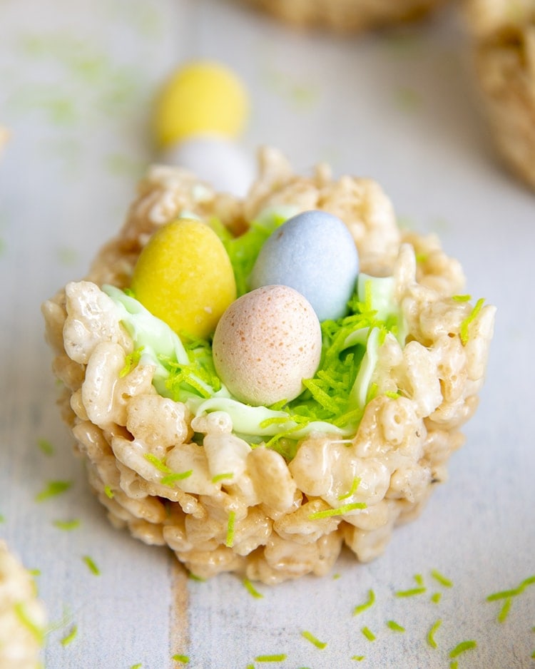 An Easter Rice Krispie treat Nest, decorated to look like a nest with green frosting and chocolate eggs to look like a bird nest.