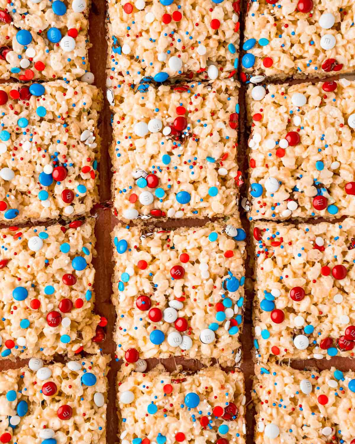 Squares of rice krispie treats topped with red white and blue mini m&ms