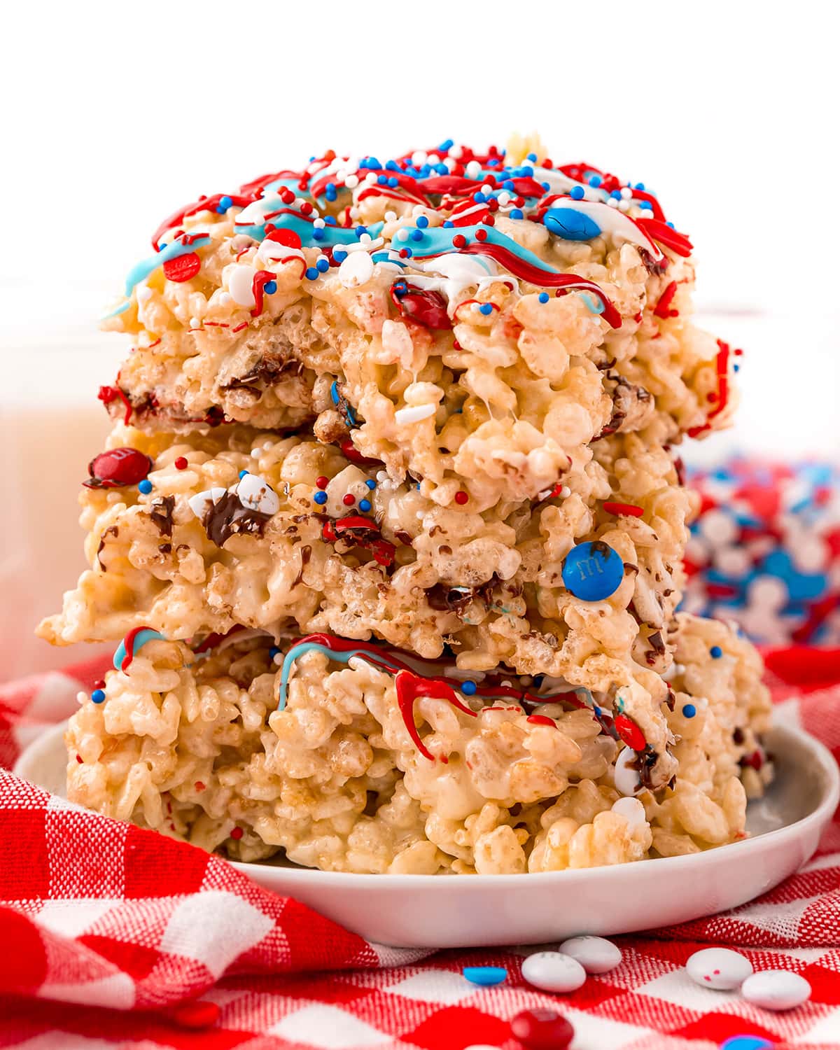 A stack of 3 rice krispie treats topped with red, white, and blue drizzled candy.