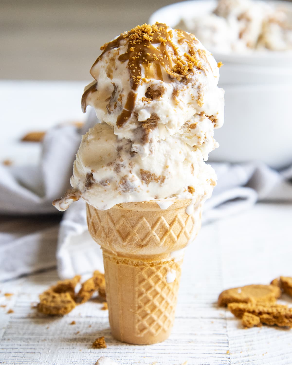 An ice cream cone topped with two scoops of Biscoff ice cream.