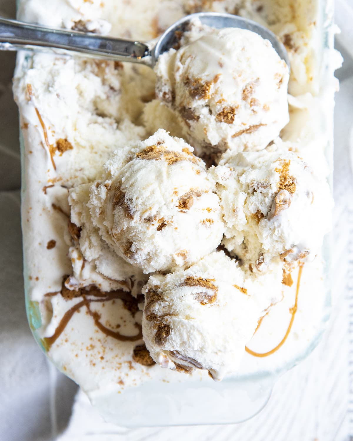 Scoops of Biscoff ice cream at the end of a pan of ice cream.