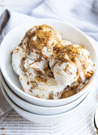 A bowl of Cookie Butter ice cream with vanilla ice cream swirled with cookie butter and Biscoff cookie crumbles.