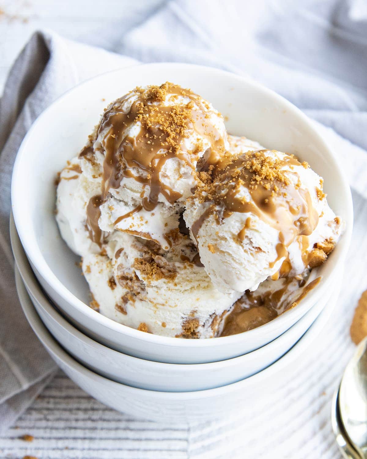 A bowl of Cookie Butter ice cream with vanilla ice cream swirled with cookie butter and Biscoff cookie crumbles.