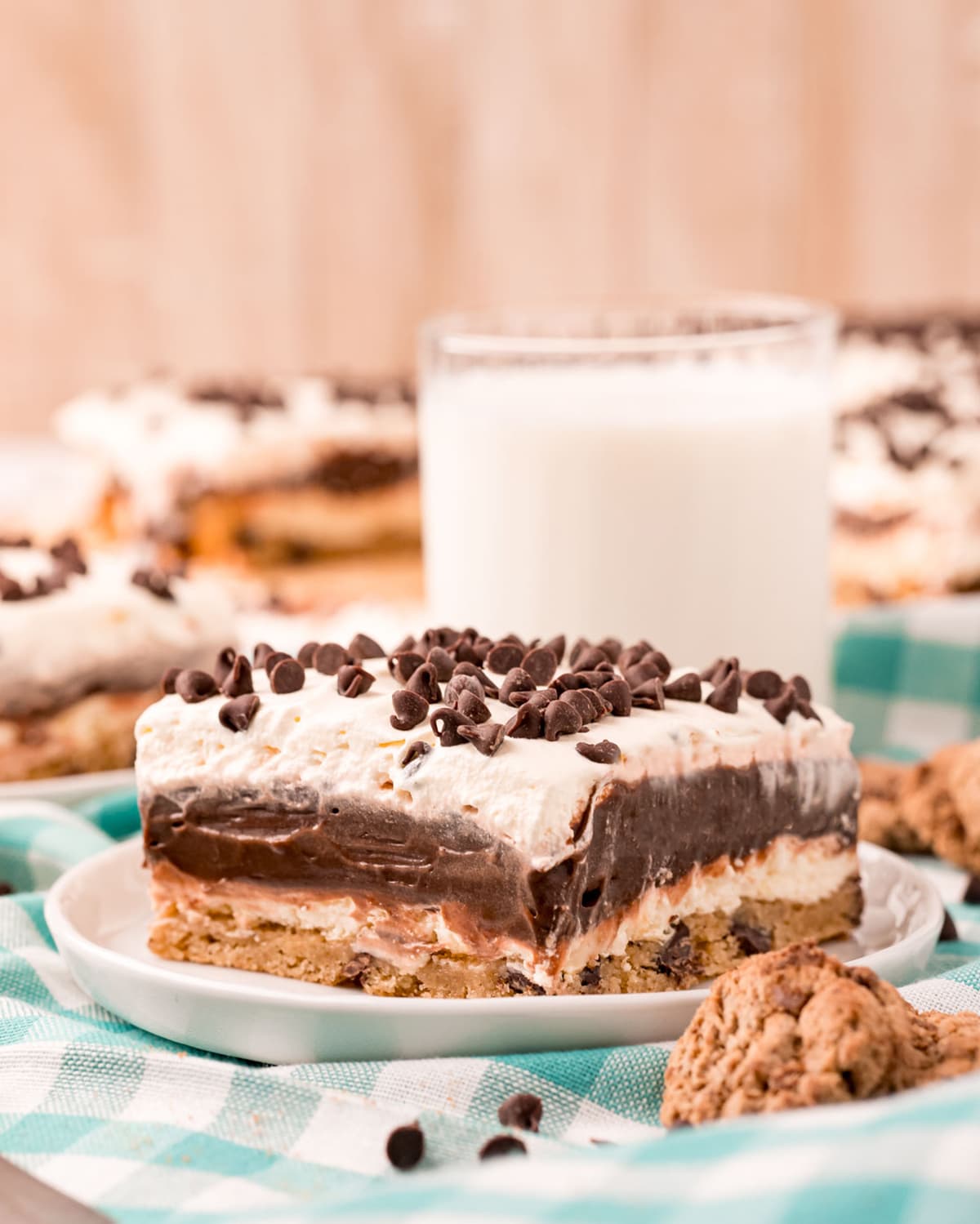 A layered chocolate dessert with whipped cream and mini chocolate chips on top.