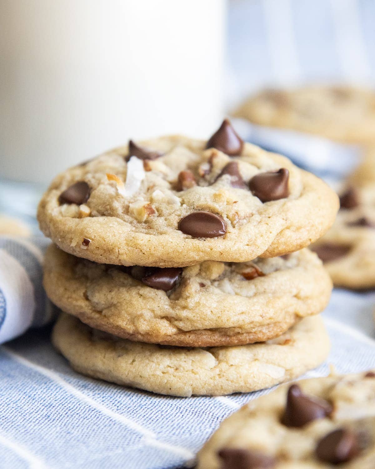 A stack of 3 drop style cookies with chocolate chips, pecans, and shredded coconut.