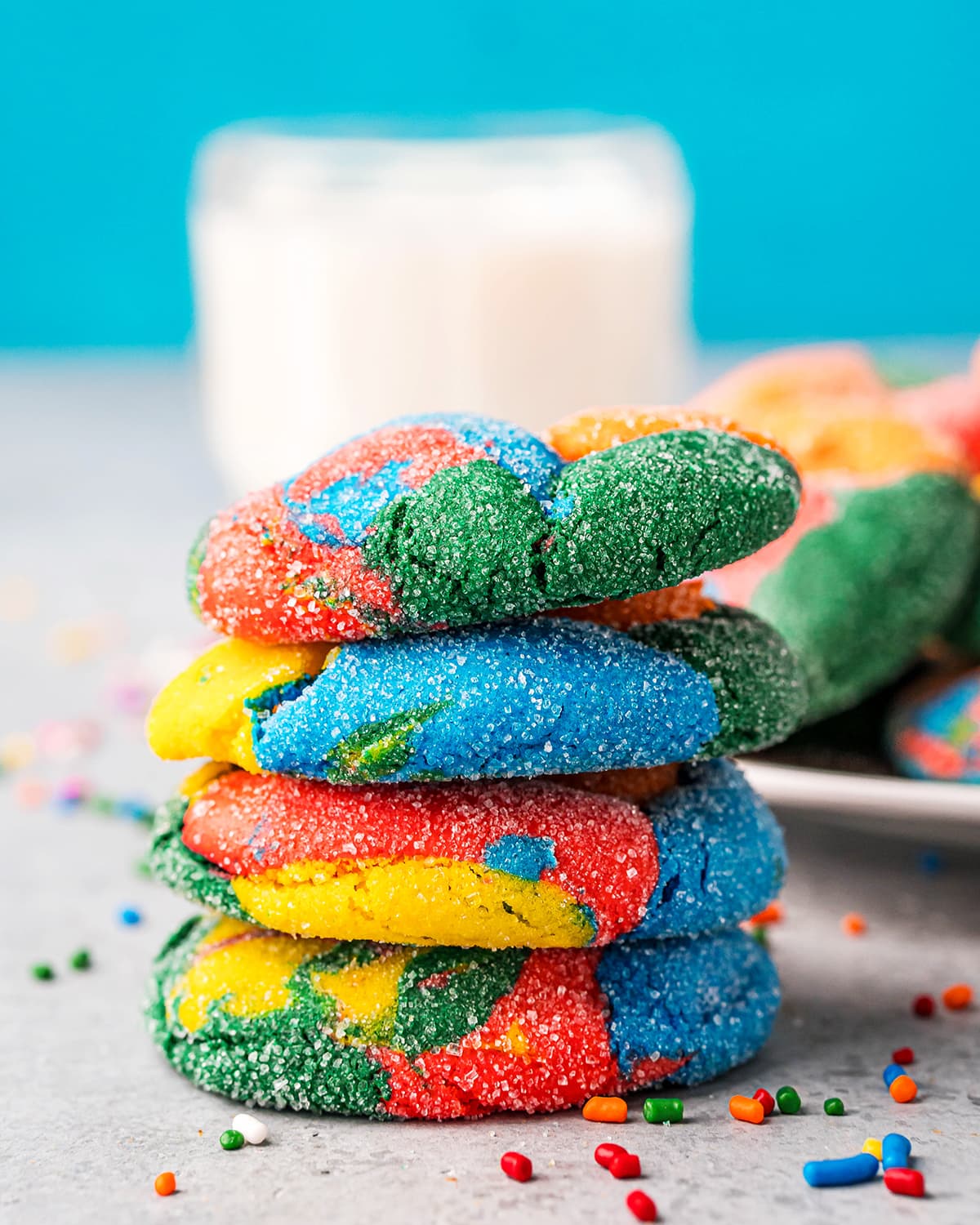 A stack of 4 puffy, rainbow colored cookies.