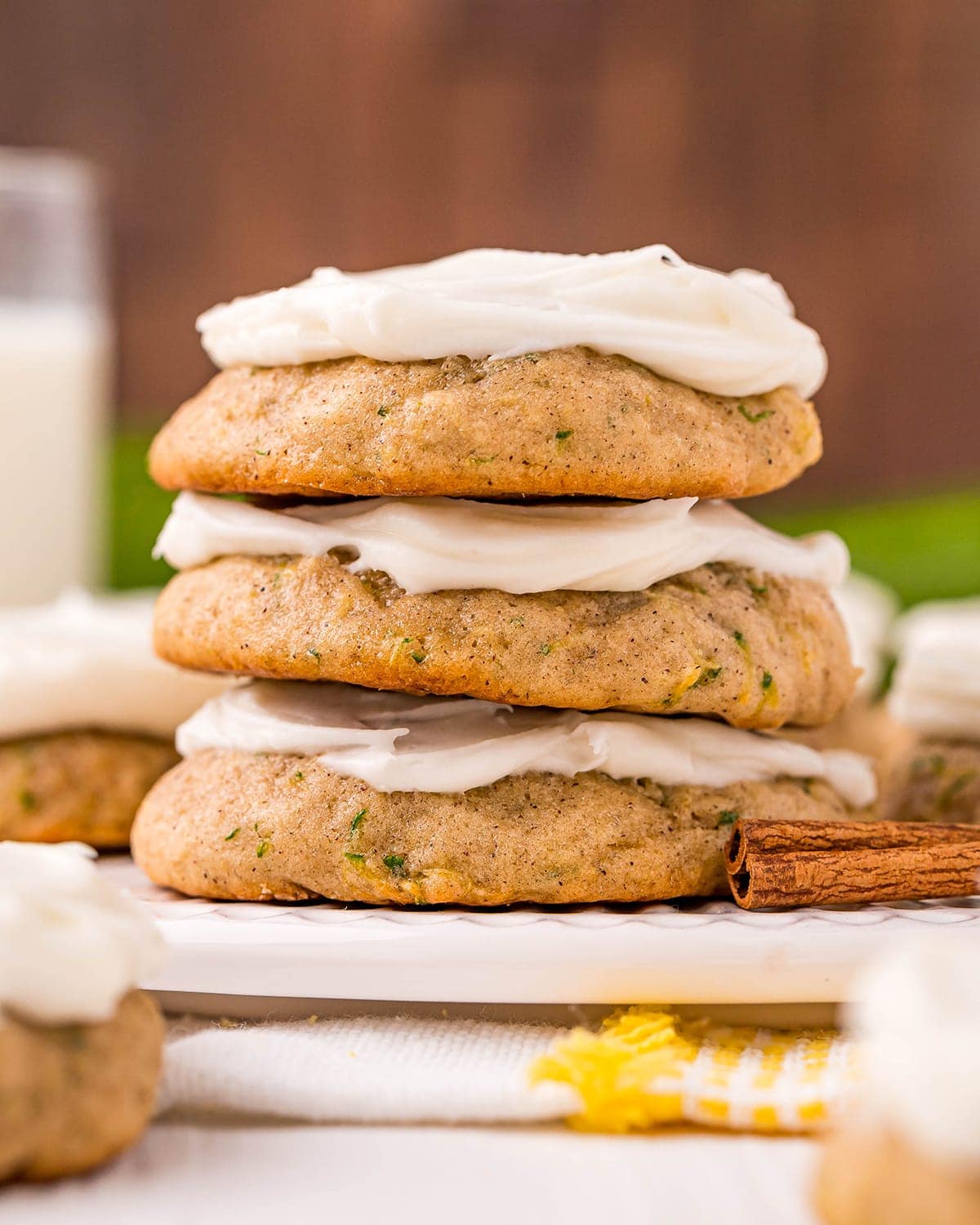 A stack of three zucchini cookies topped with cream cheese frosting.