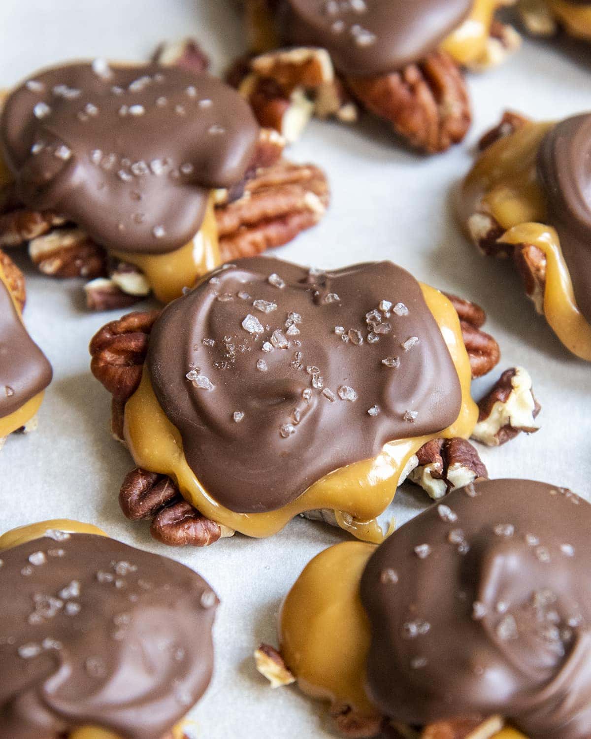 Homemade chocolate turtles with pecans, caramel, chocolate and sea salt.