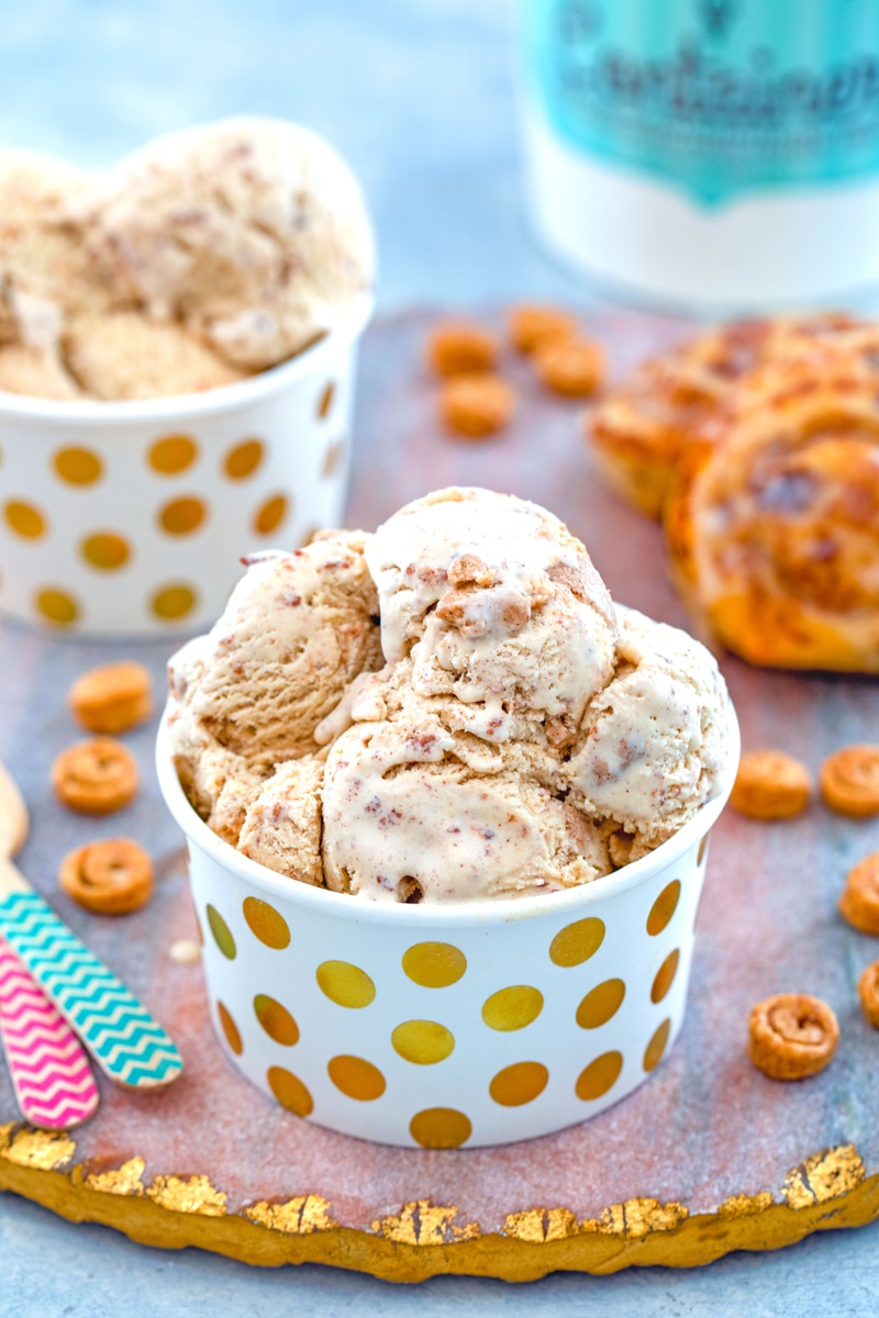 A paper cup full of cinnamon roll ice cream with swirls of cinnamon throughout.