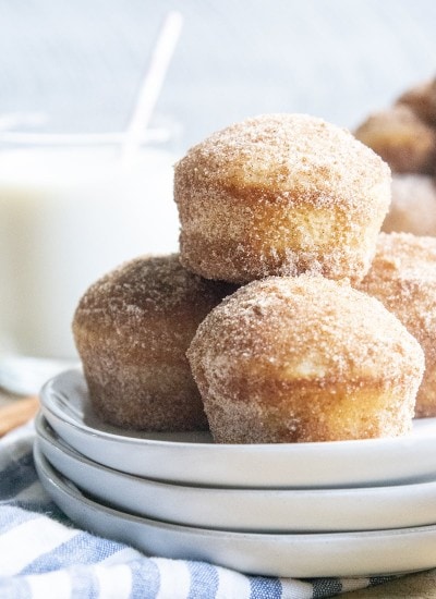A pile of cinnamon sugar donut muffins on a white plate.