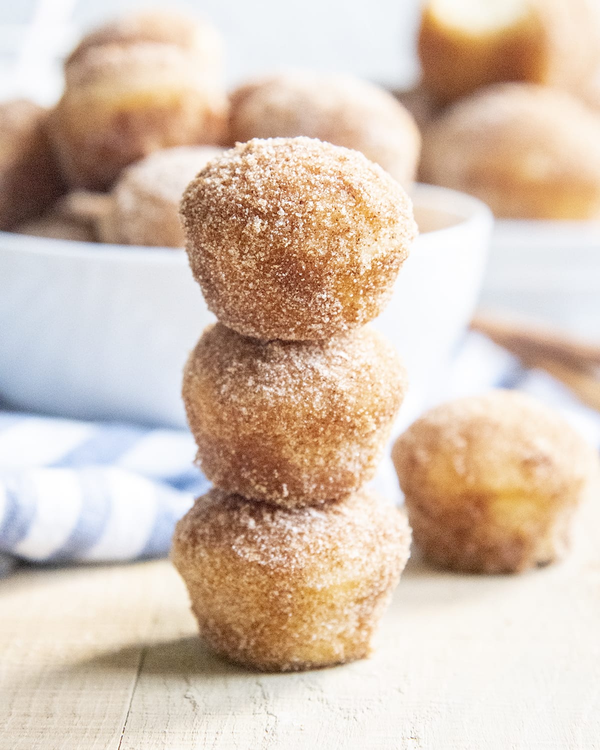 A stack of three mini cinnamon sugar muffins.