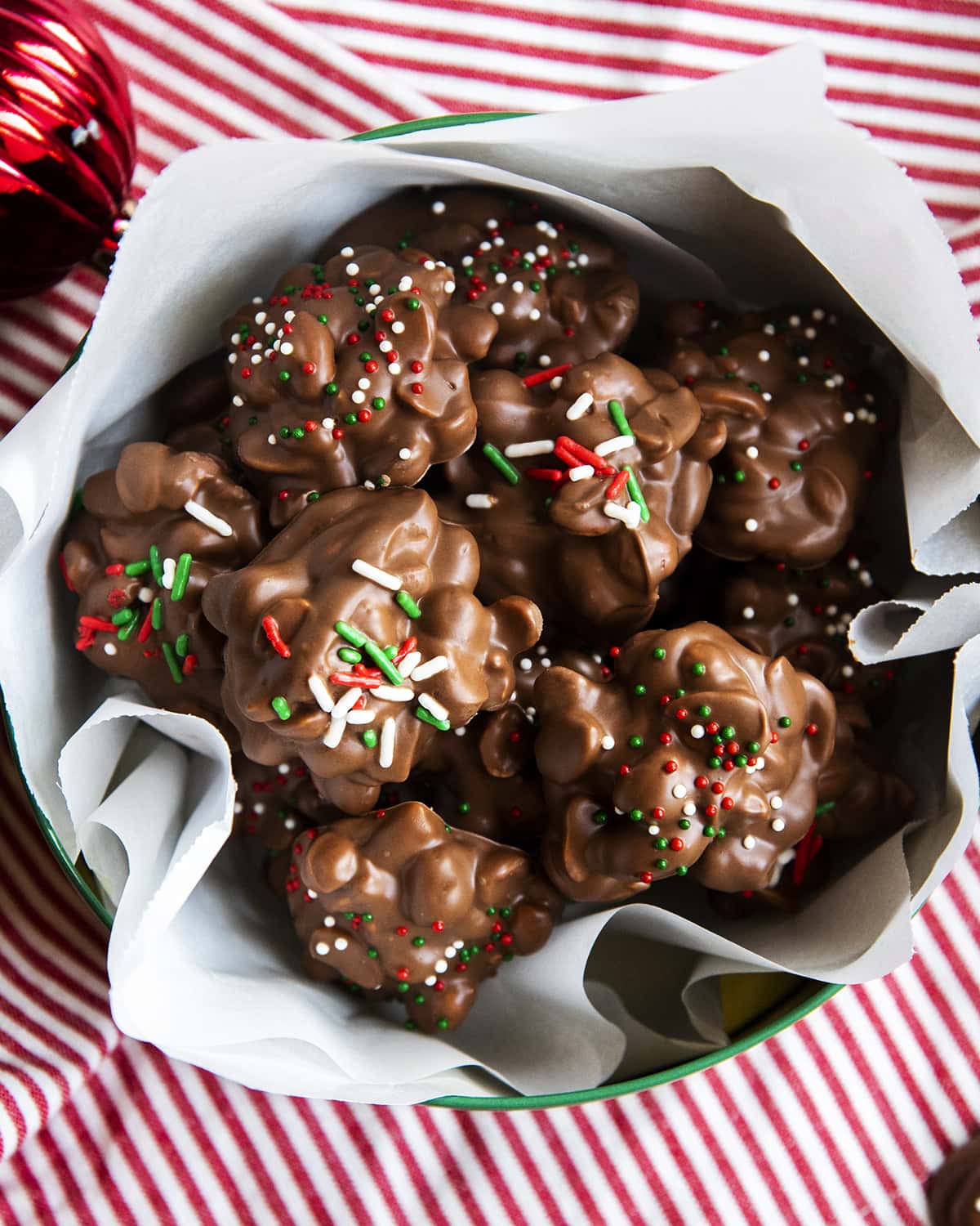 A metal tin full of a chocolate peanut clusters.