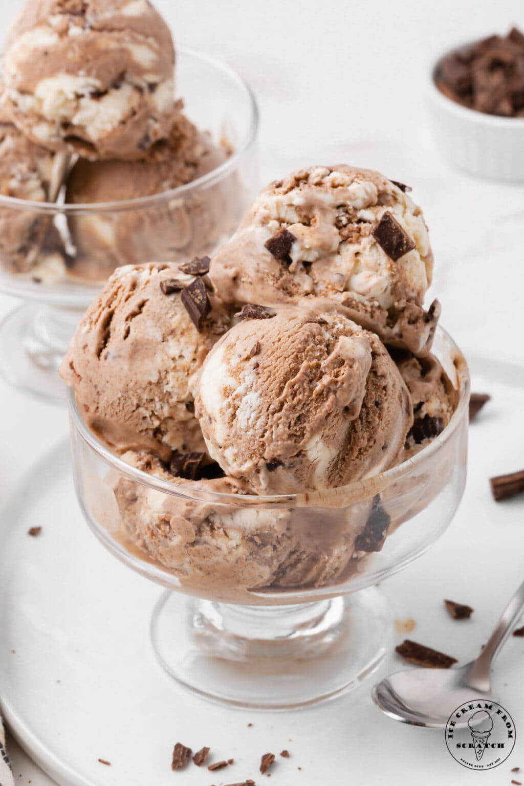 A glass container overflowing with scoops of chocolate frenck silk ice cream.