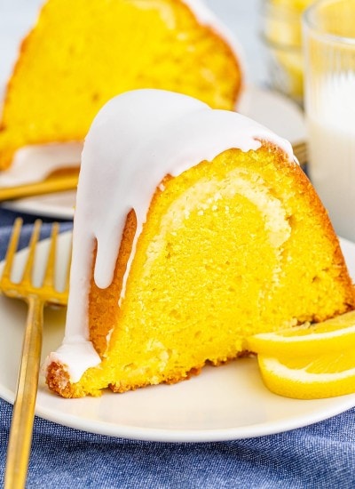 A slice of lemon bundt cake with glaze on a white plate.