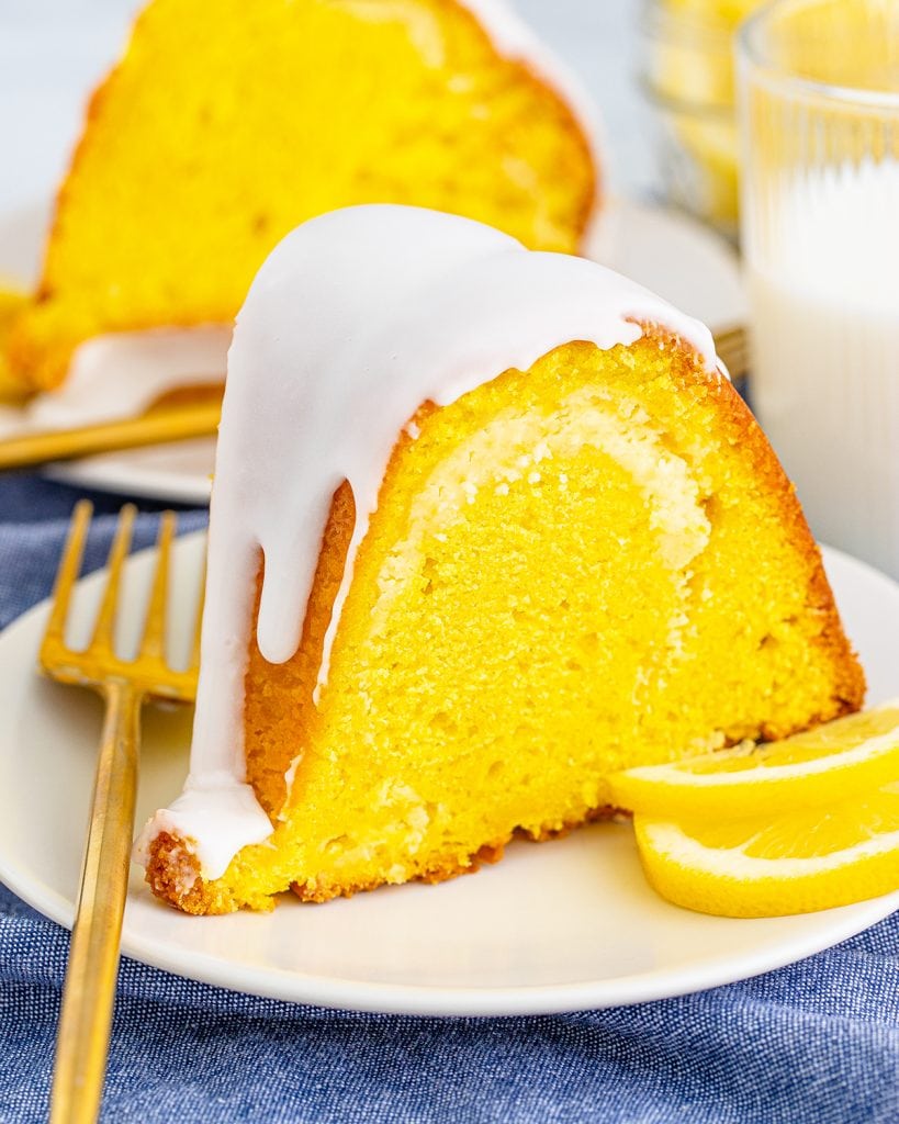 A slice of lemon bundt cake with glaze on a white plate.