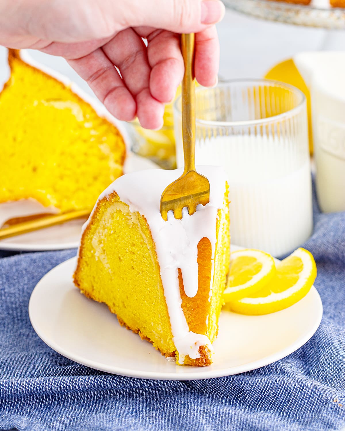 A piece of lemon bundt cake with a fork in the cake slice.