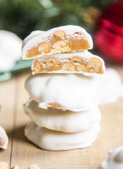 A stack of white chocolate covered caramel pecan clusters.