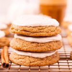 A stack of three cream cheese frosted pumpkin cookies.