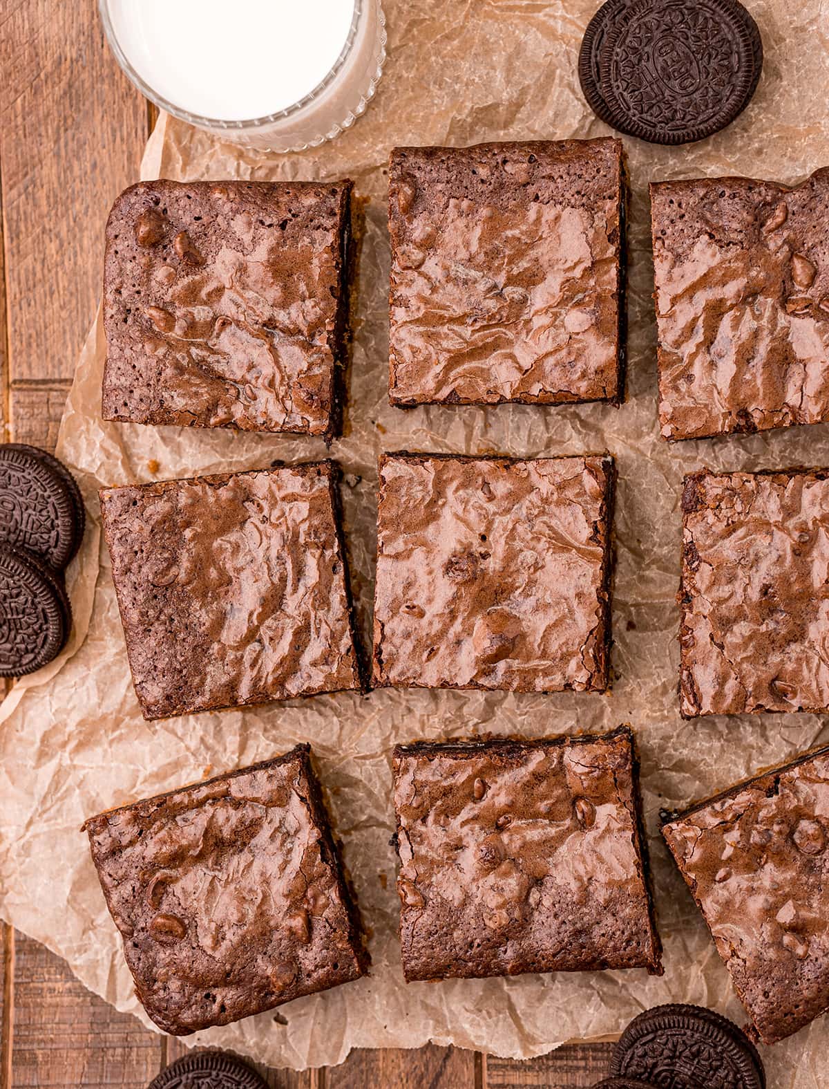 An overhead photo of brownie squares on brown parchment paper.
