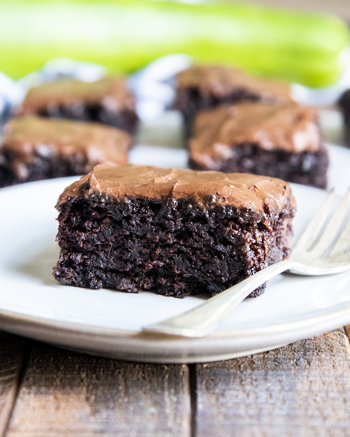 A zucchini brownie on a plate, with a fork next to it.