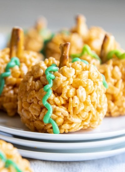 A close up of a pumpkin spice rice krispie treat that is also shaped like a pumpkin.
