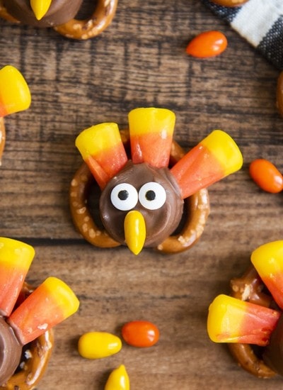 A pretzel topped with a rolo and decorated with candy corn, candy eyes, and a chocolate covered sunflower seed to make it look like a turkey.