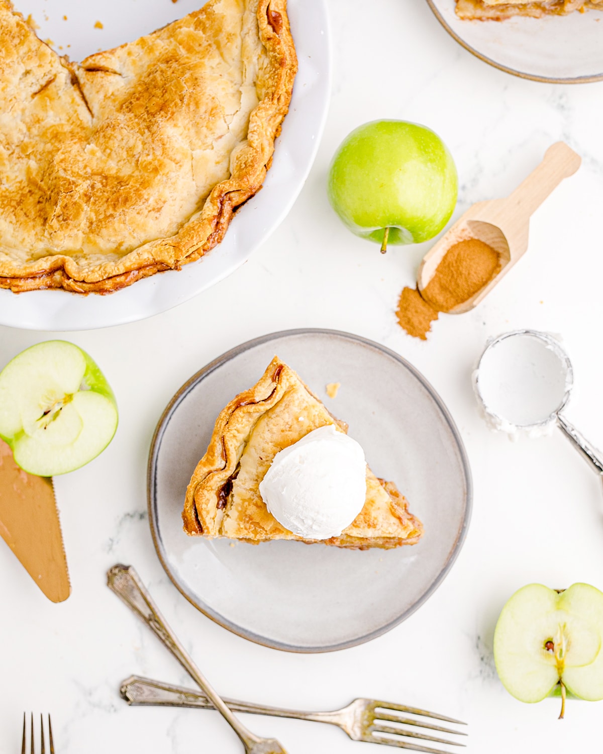 An overhead photo of a slice of apple pie with a scoop of vanilla ice cream on top.