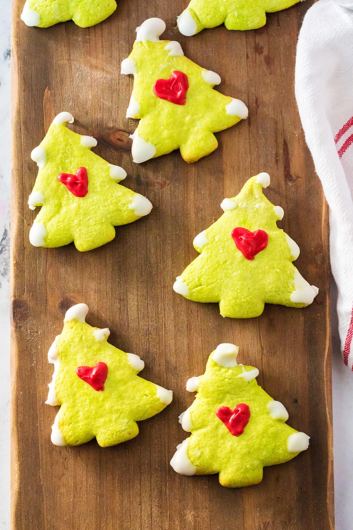 Grinch Christmas Tree Cookies on a wooden board.