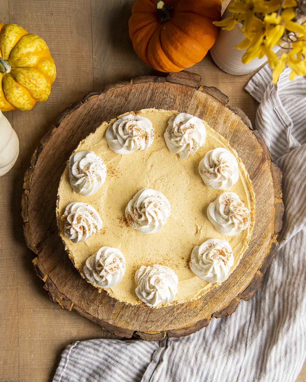 An overhead photo of a no bake pumpkin cheesecake on a round wooden board.