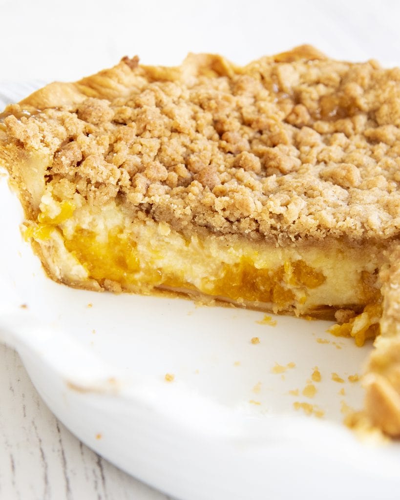 A sour cream pie pie in a pan that is cut open showing the inside of the pie/