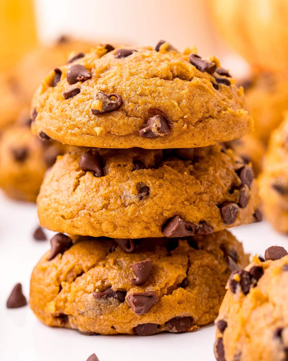 A close up of a stack of pumpkin chocolate chip cookies.