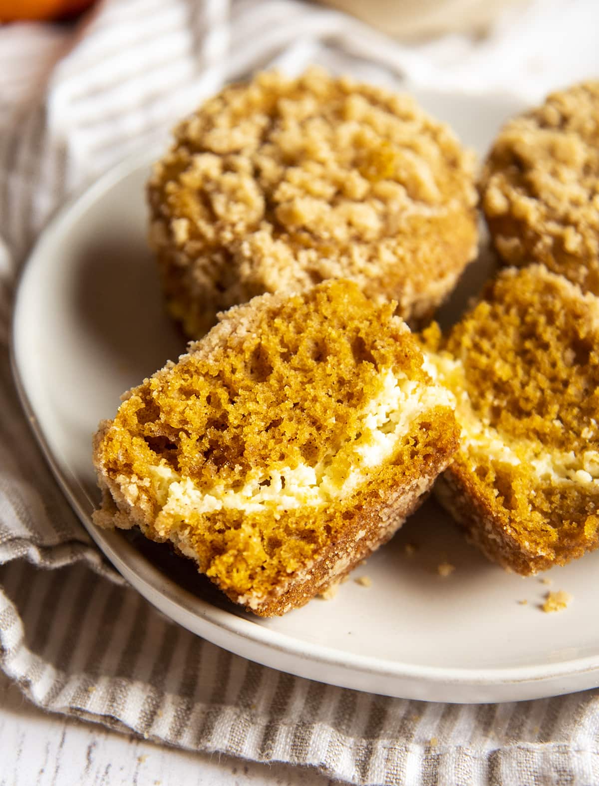 A pumpkin muffin cut in half with a cream cheese swirl in the middle.
