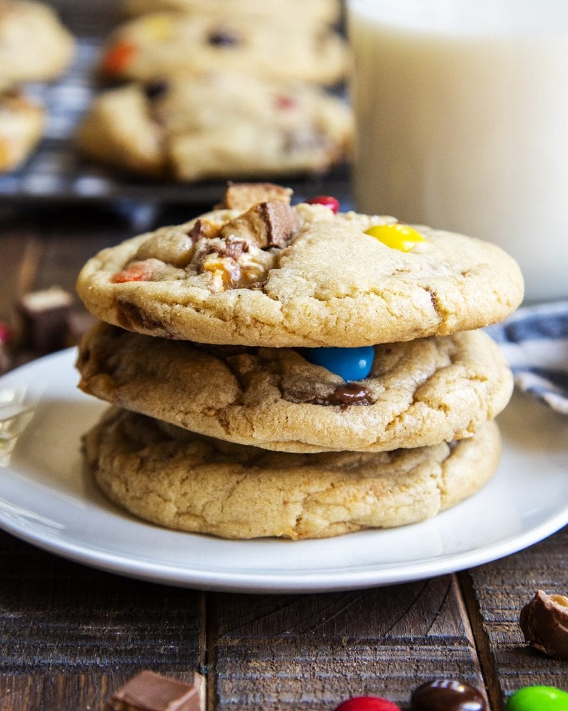 A stack of three large candy bar cookies on a plate.