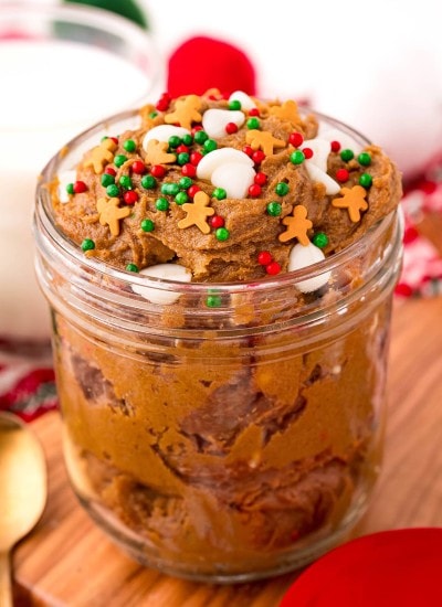 A jar of edible gingerbread cookie dough topped with Christmas sprinkles.