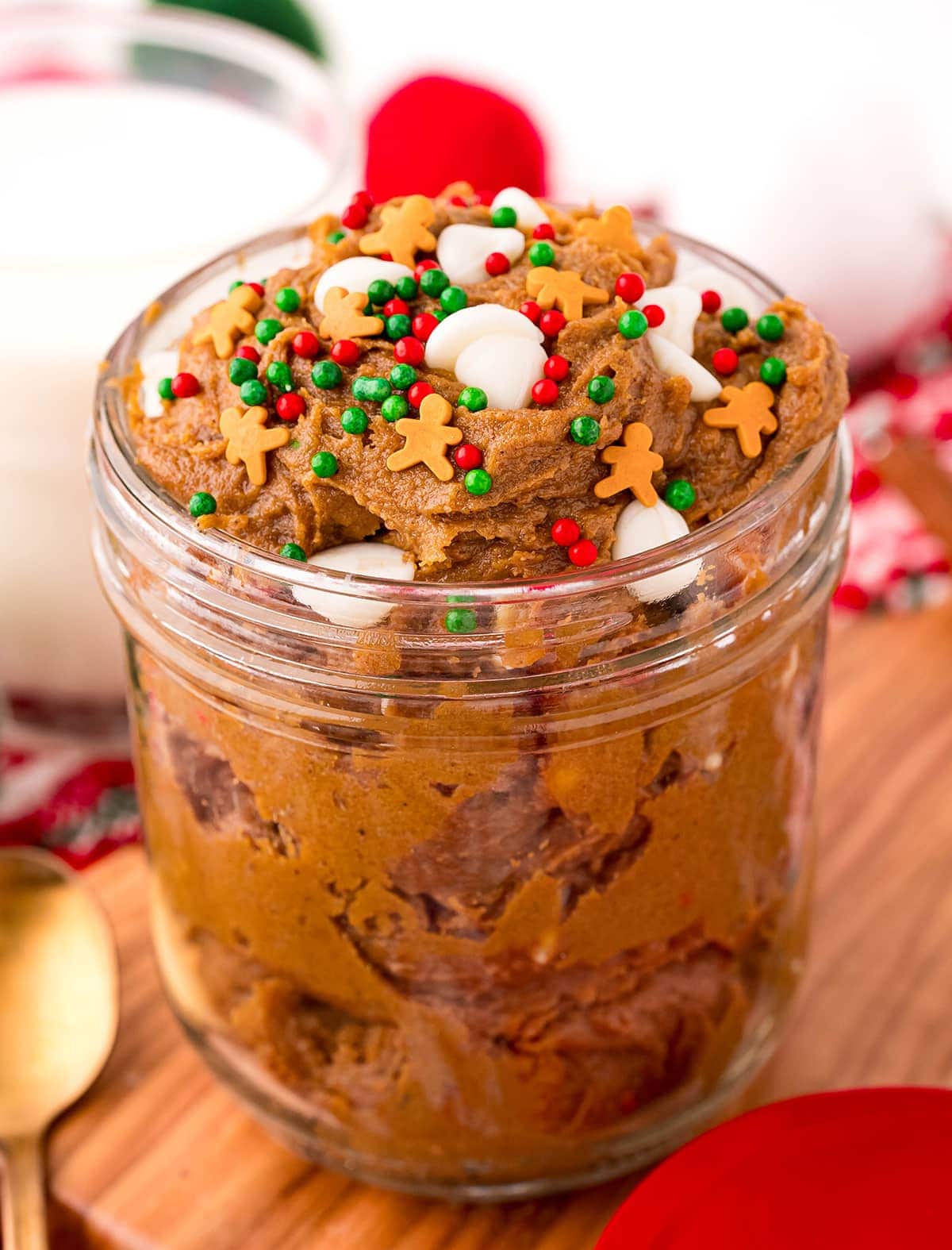 A jar of edible gingerbread cookie dough topped with Christmas sprinkles.