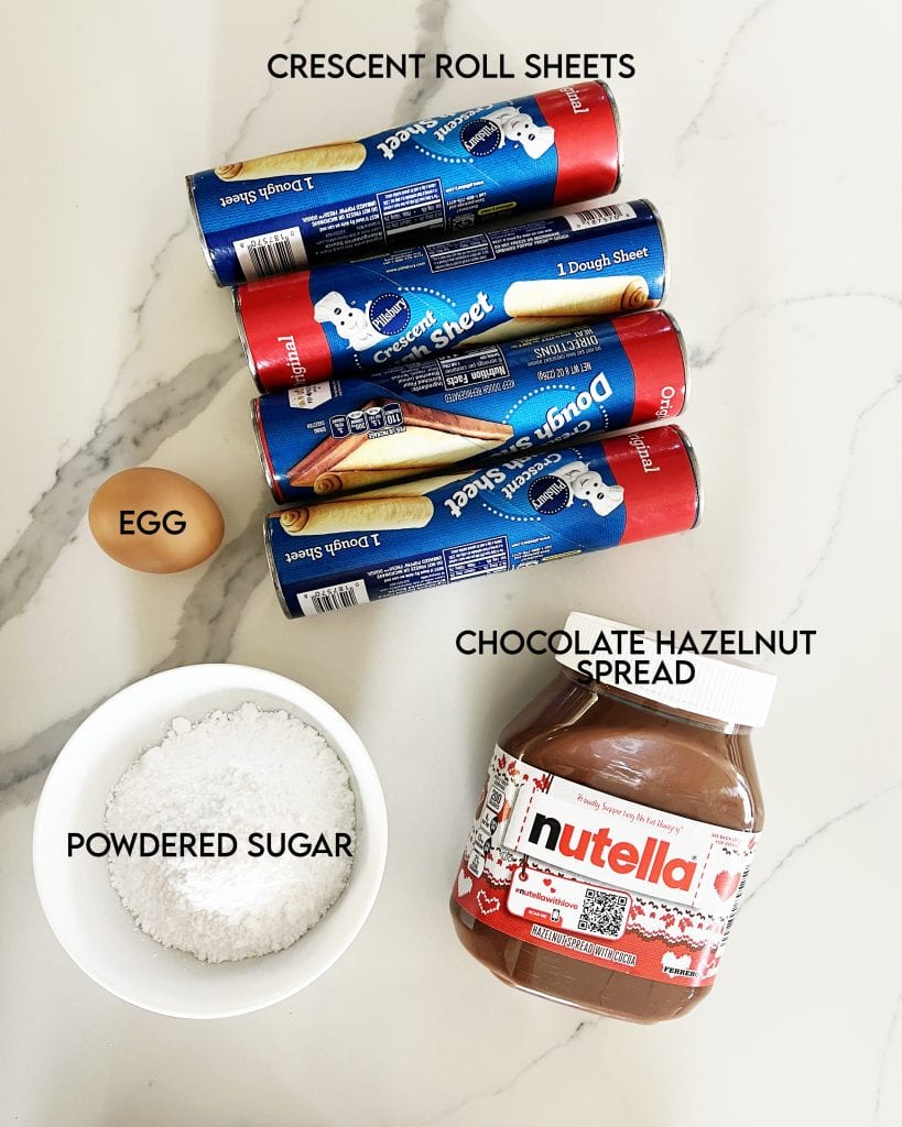 The 4 ingredients needed to make Nutella Star Bread, Crescent Roll Sheets, an Egg, Powdered Sugar, and Nutella