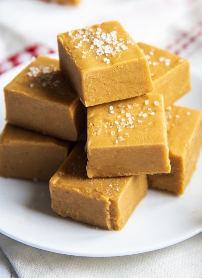 A pile of salted caramel fudge each topped with coarse sea salt.