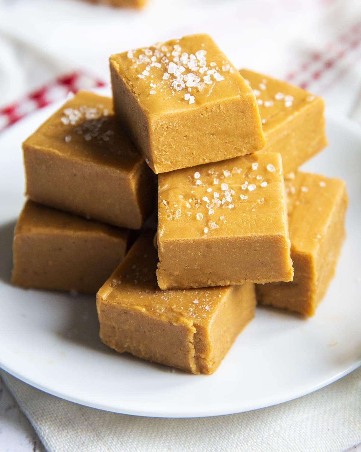 A pile of salted caramel fudge each topped with coarse sea salt.