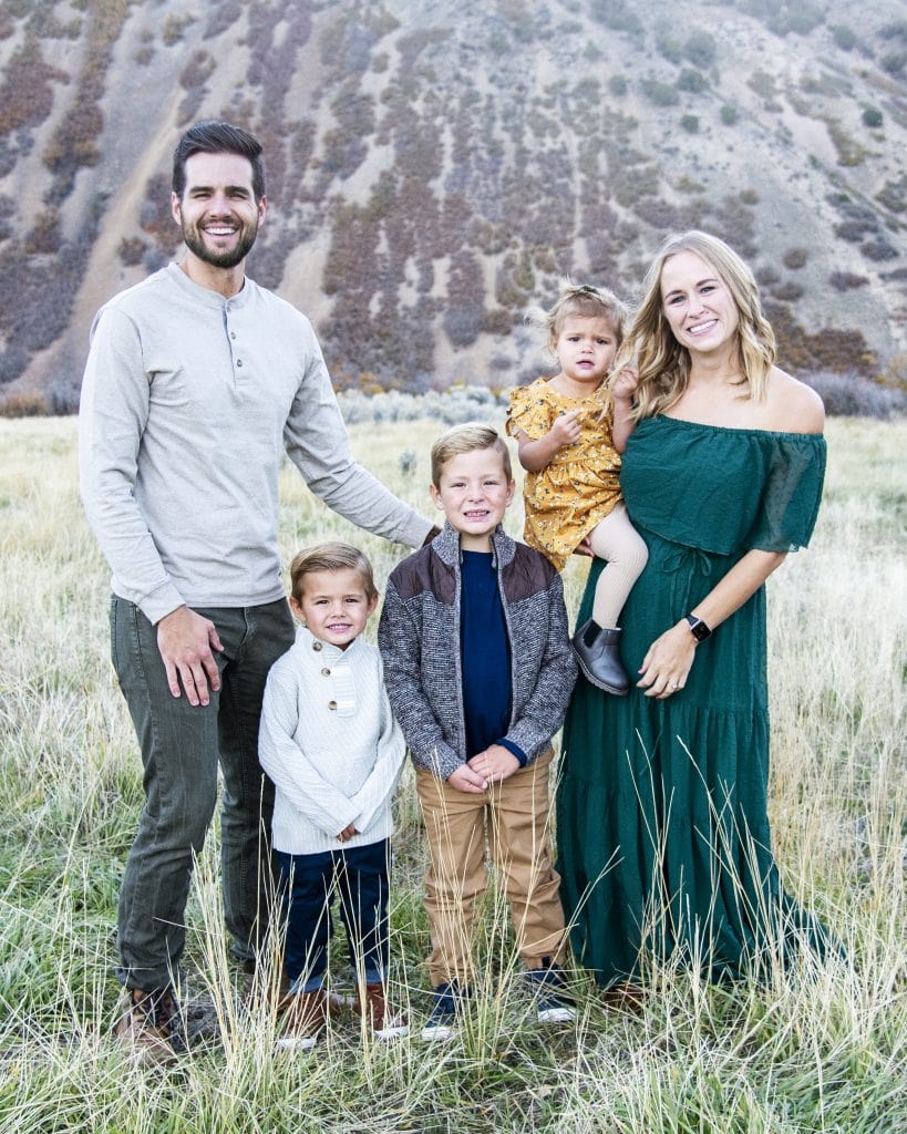 A family of five people smiles at the camera.