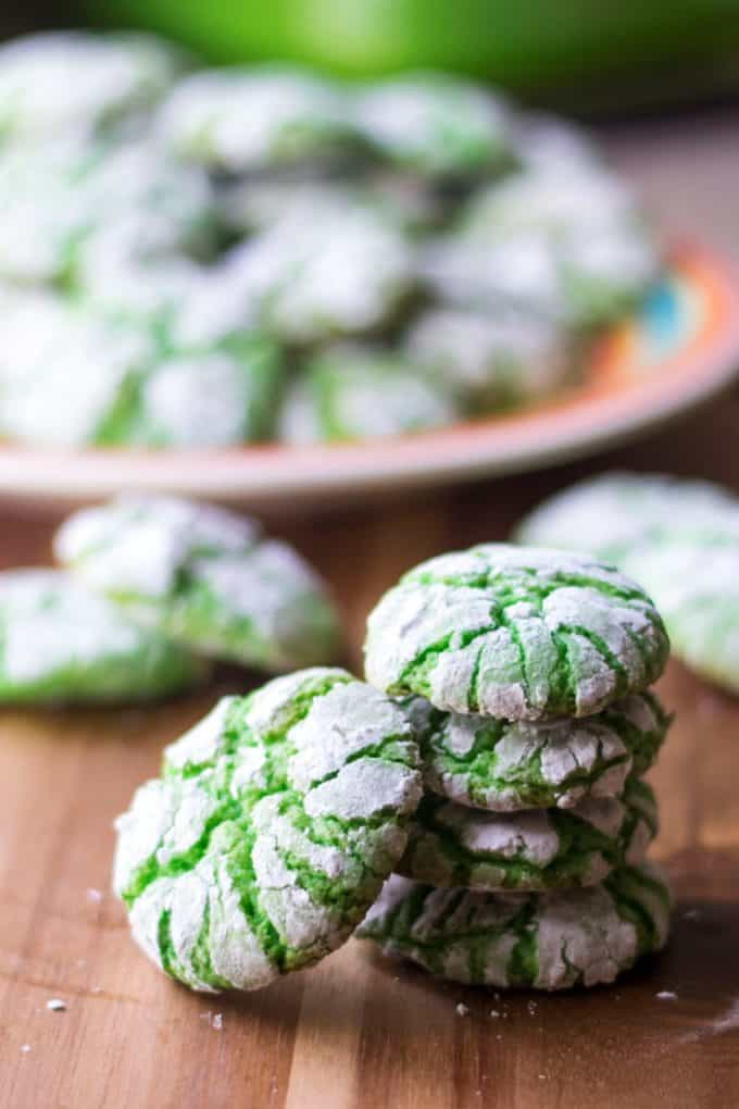 A stack of green crinkle cookies, coated in powdered sugar crinkles.