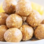 A close up of a pile of energy balls with lemons behind them.