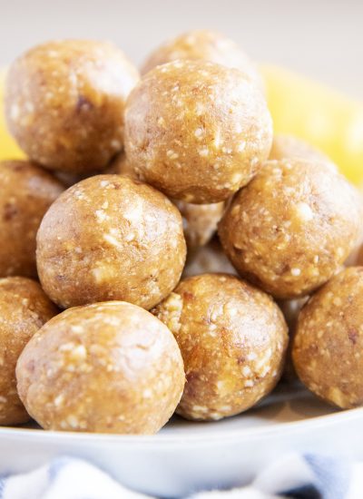 A close up of a pile of energy balls with lemons behind them.