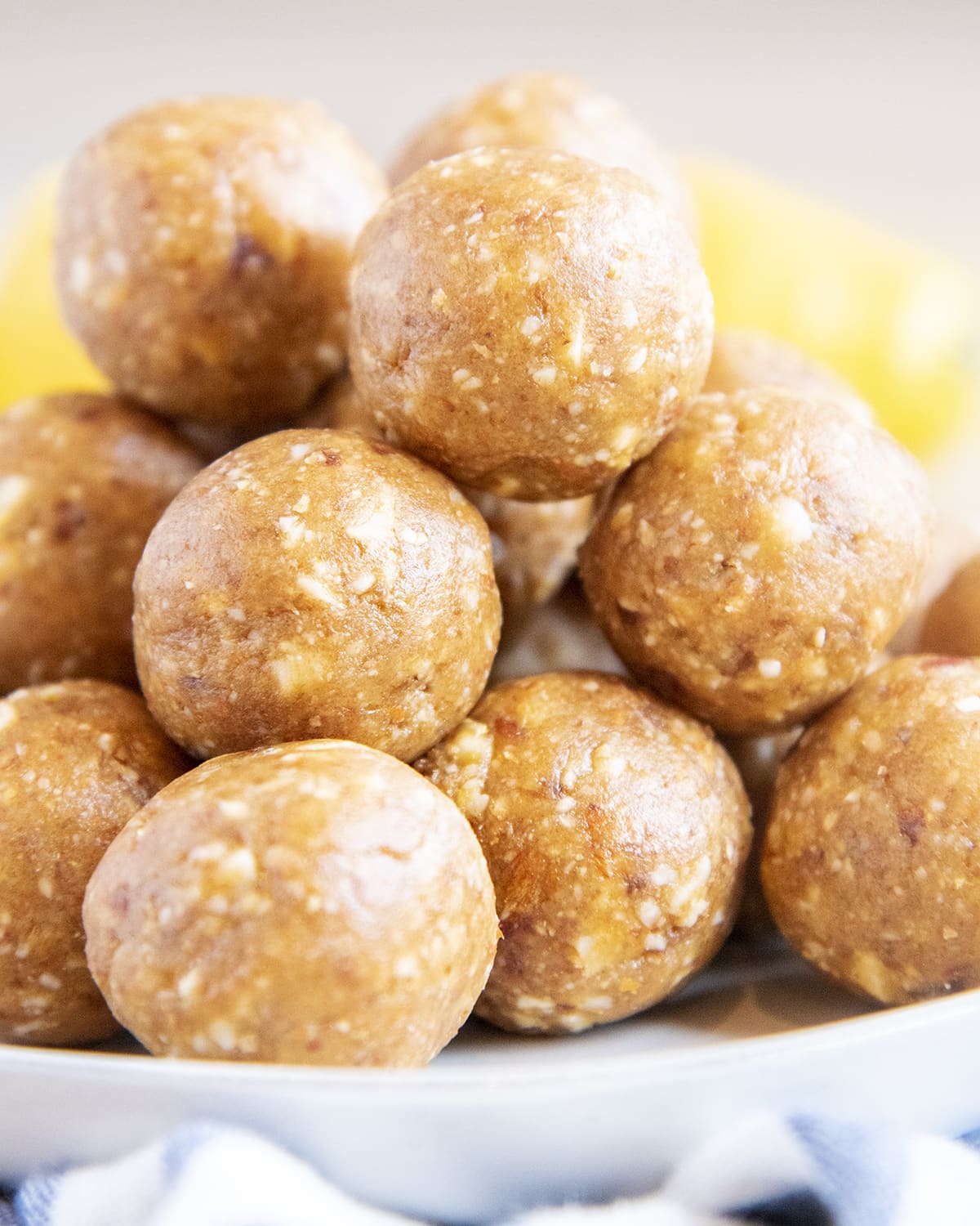 A close up of a pile of energy balls with lemons behind them.