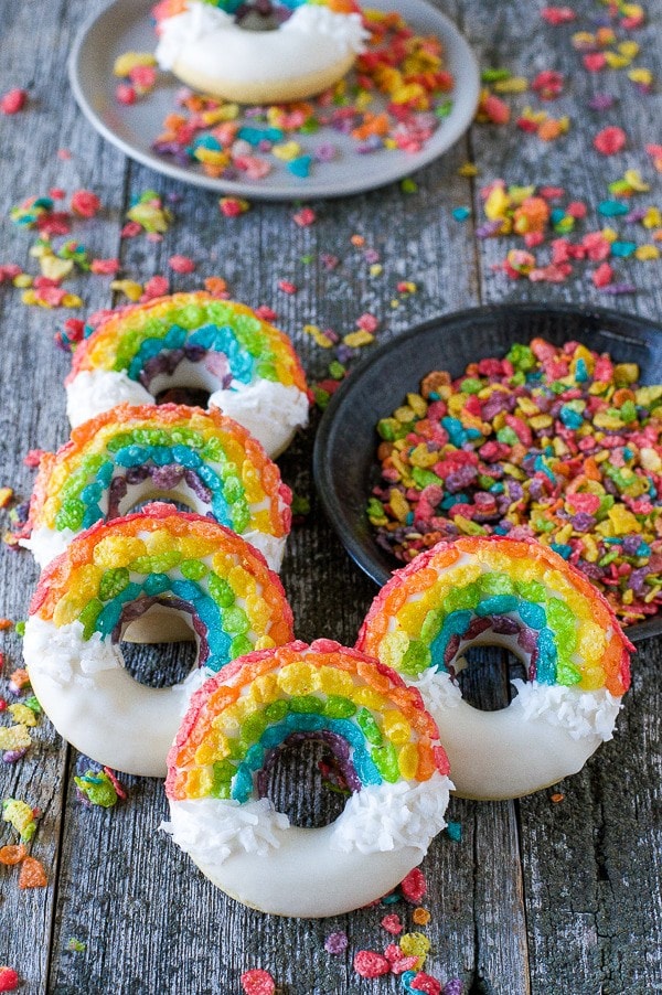Donuts decorated with fruity pebbles to look like rainbows.