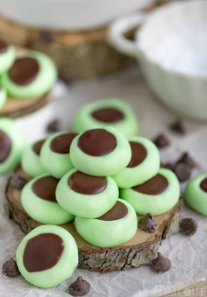 A pile of green cream cheese mints filled with a chocolate ganache center.