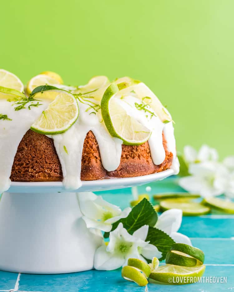 A lime bundt cake on a white cake stand.