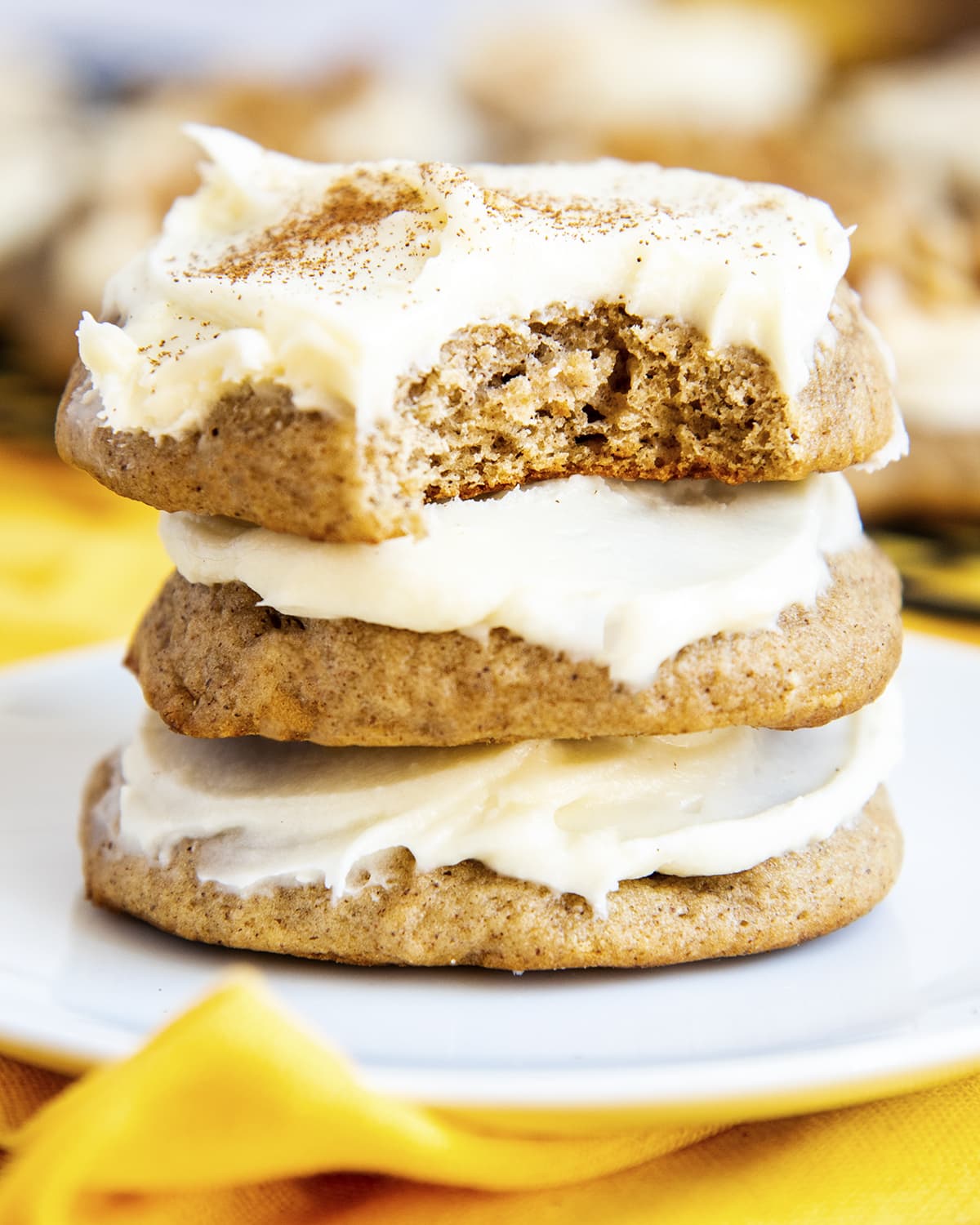 A stack of three banana bread cookies, the top cookie has a bite taken out of it.