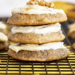 A stack of three banana cookies with cream cheese frosting on top.